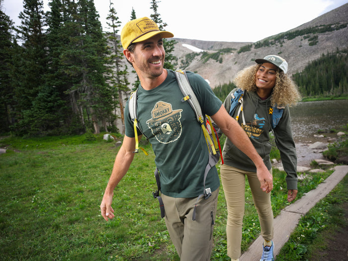 A couple in the Rockies wearing Smokey Bear apparel