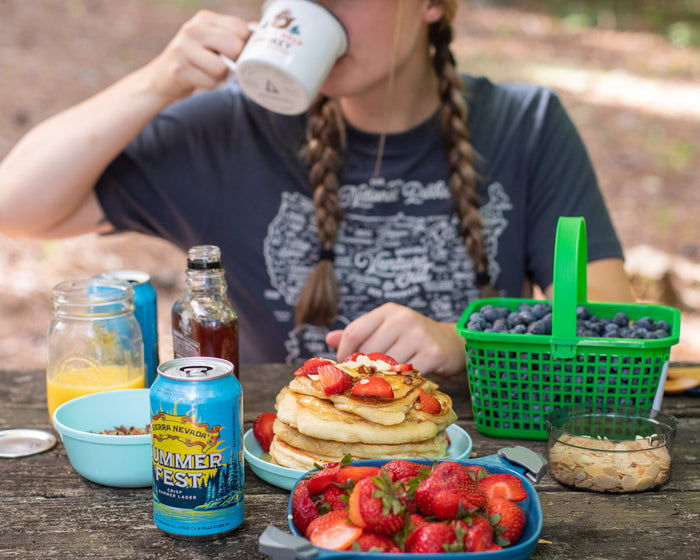 Woman drinking while sitting down for breakfast pancakes